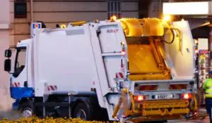 a garbage truck and sanitation worker